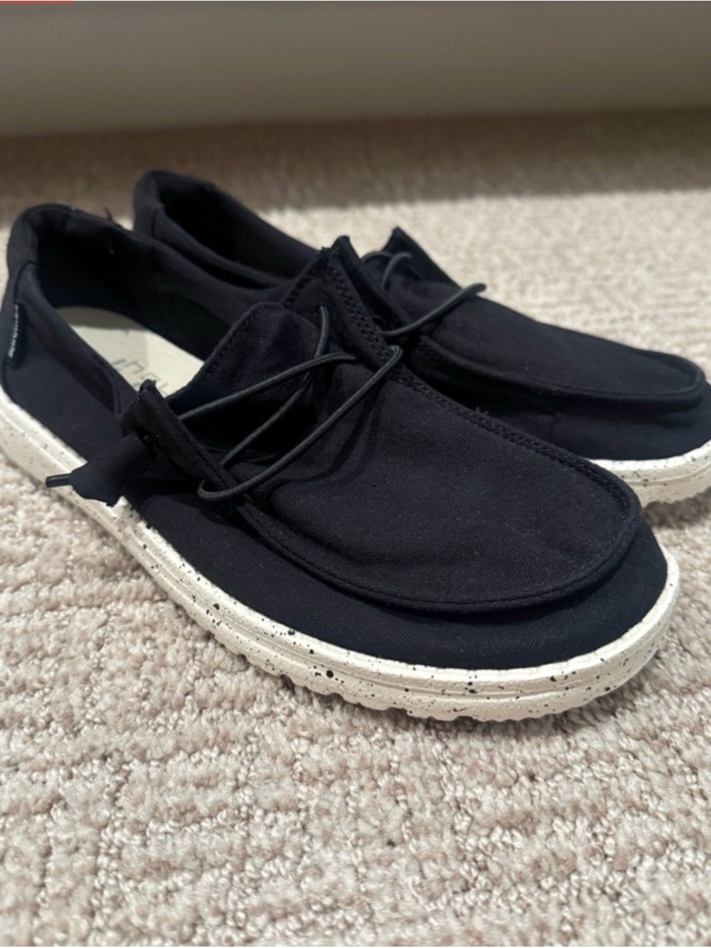 HEYDUDE Black Canvas Slip-Ons with Speckled White Sole